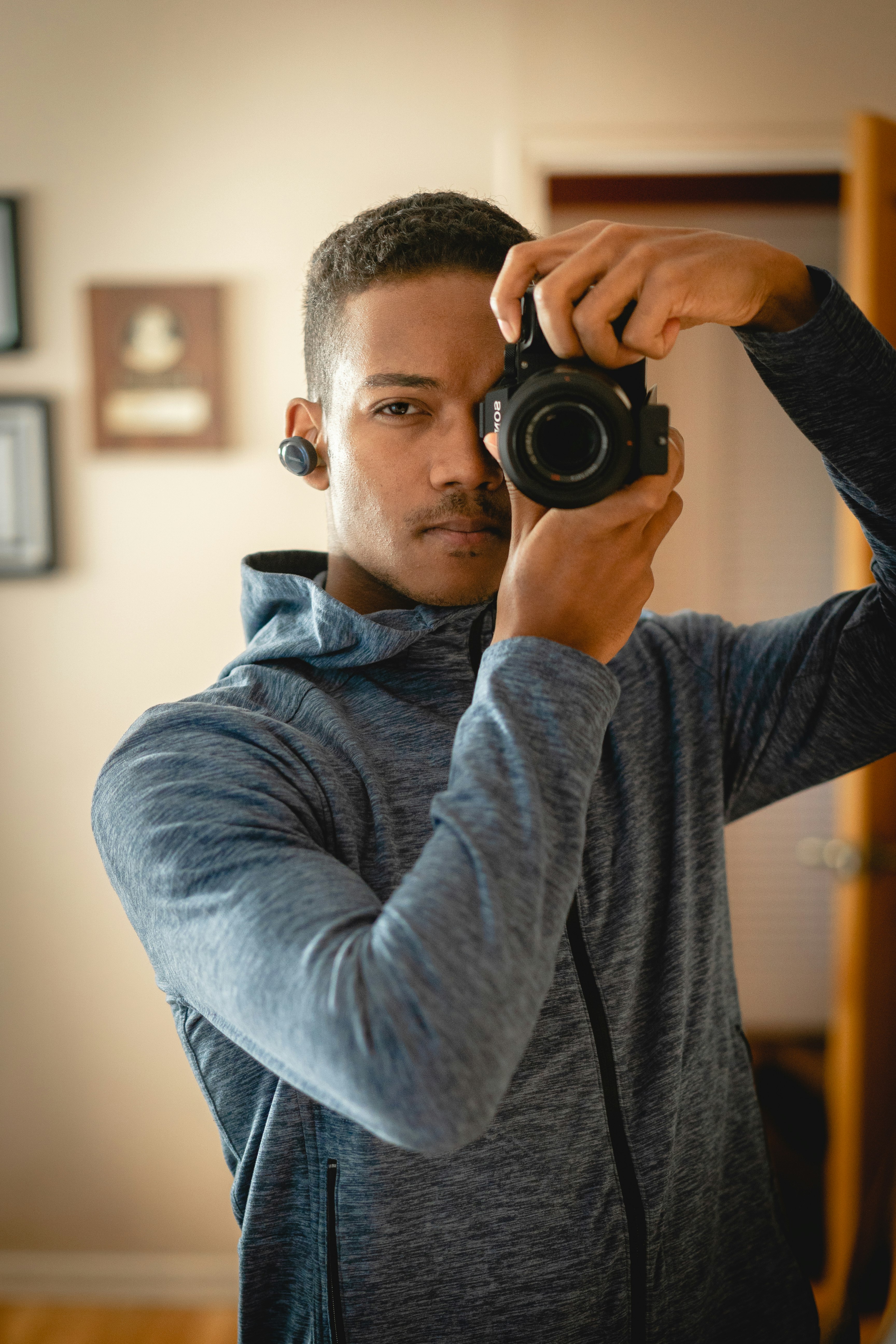 man in gray long sleeve shirt holding black dslr camera